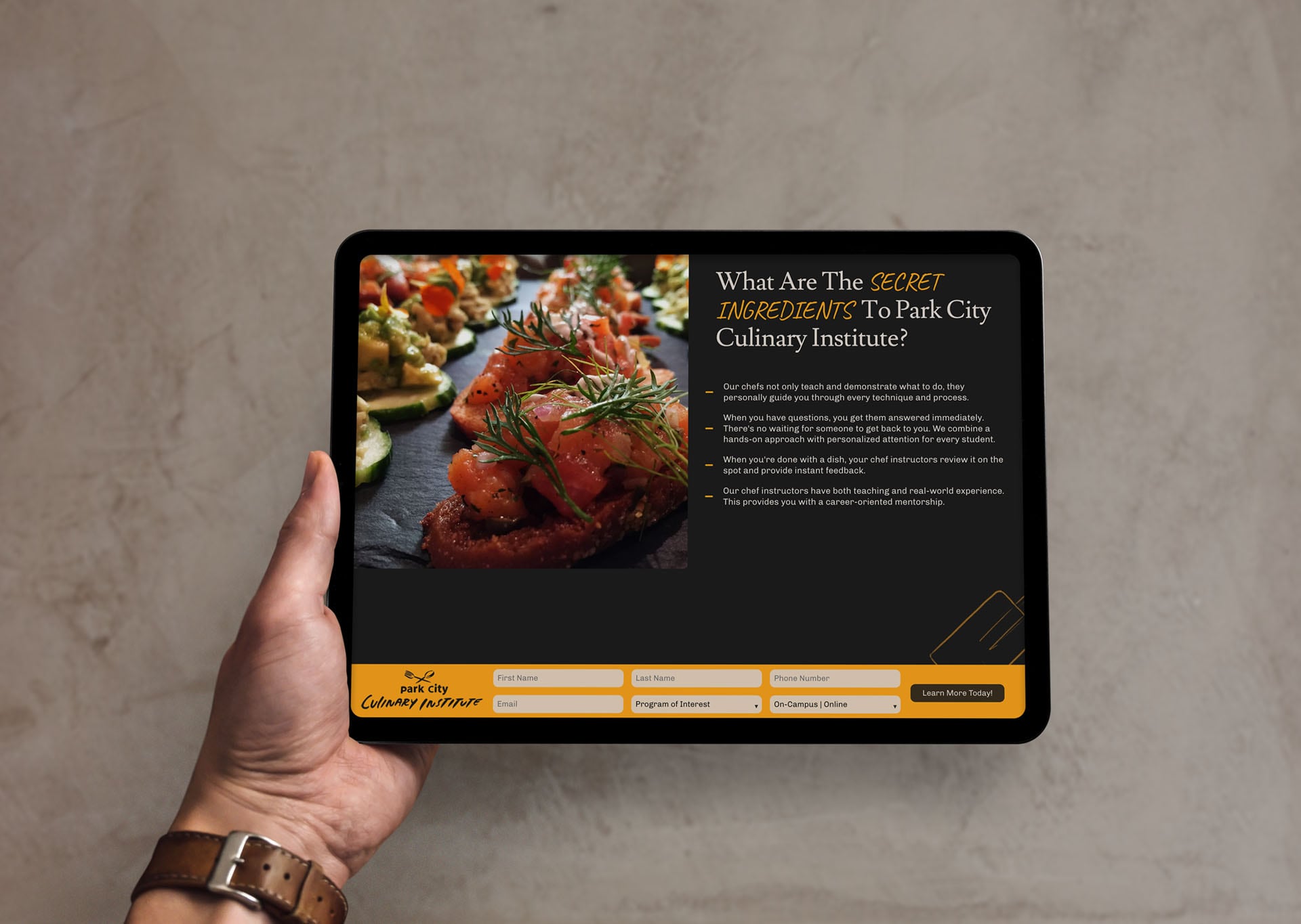 Park City Culinary Institute landing page displayed on a horizontal tablet held in somebody's hand.
