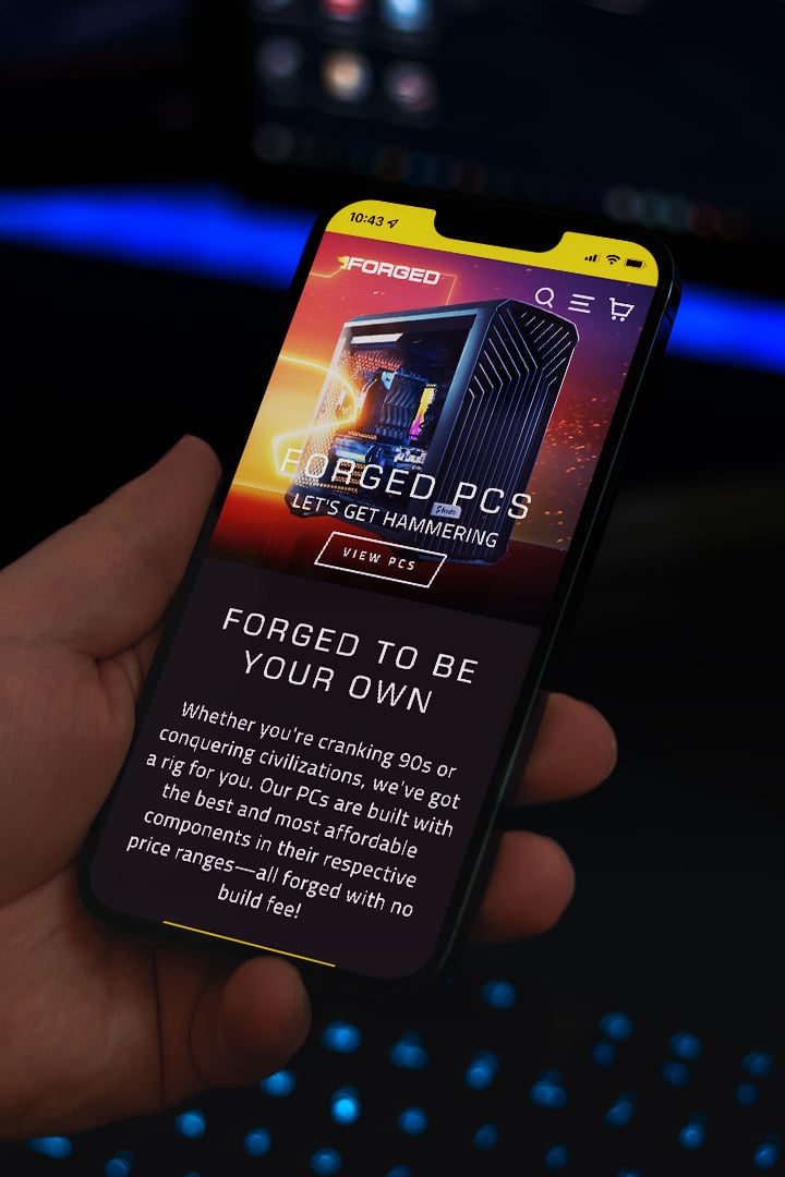 The Forged PCs homepage displayed on a mobile phone in somebody's hand.