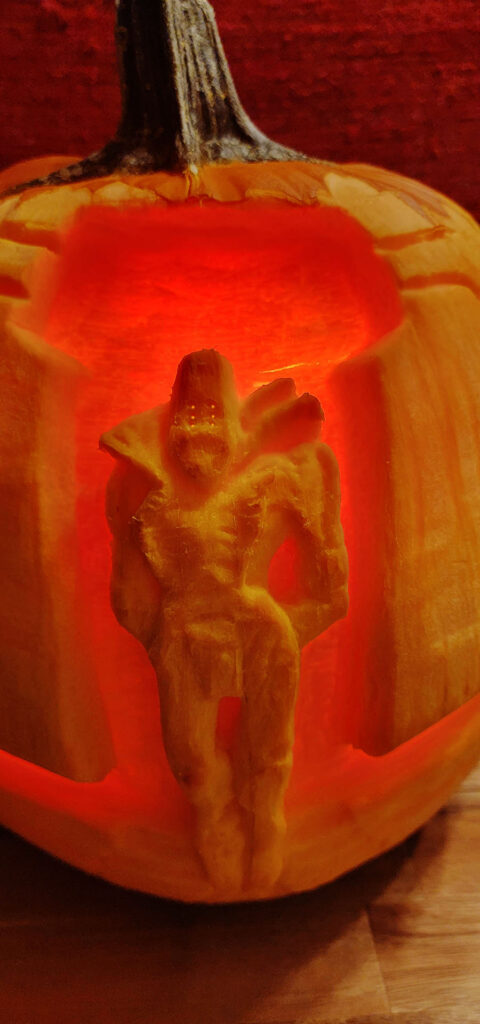 Close-up detail of the pumpkin carving of Rhulk, First Disciple of the Witness. Rhulk's whole body was carved in relief on the pumpkin, framed by the Upended behind him.