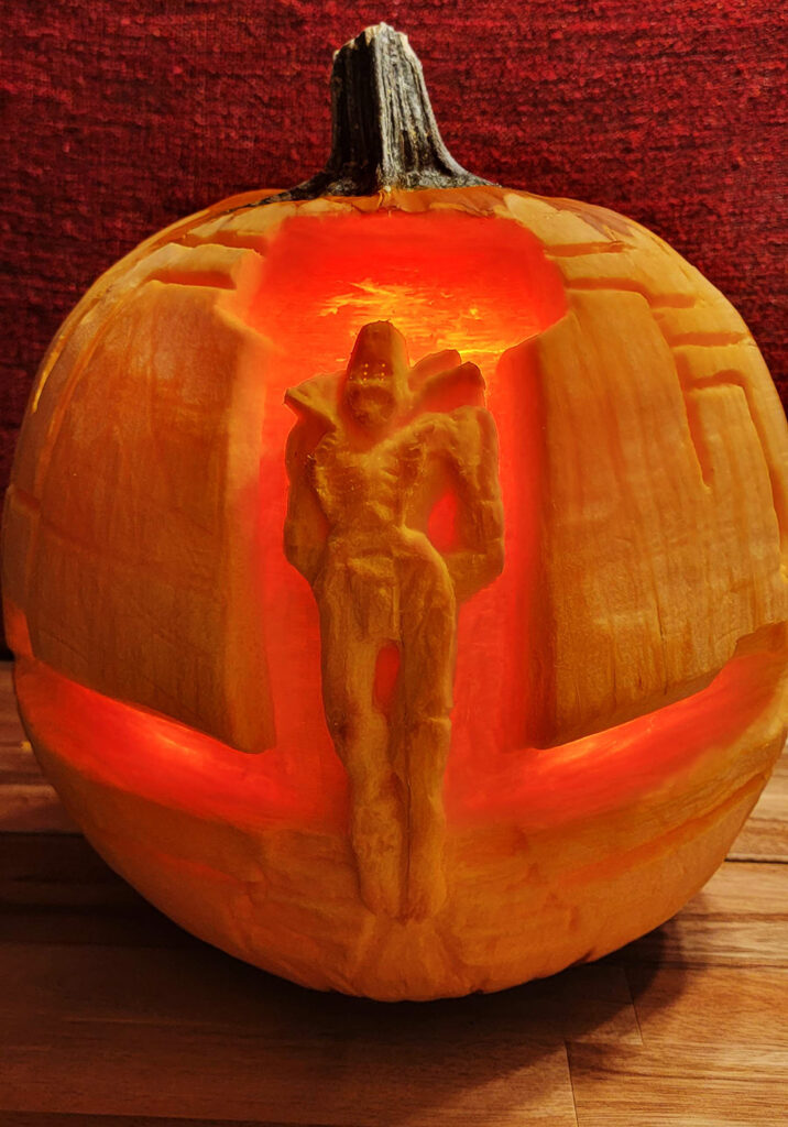 Close-up detail of the pumpkin carving of Rhulk, First Disciple of the Witness. Rhulk's whole body was carved in relief on the pumpkin, framed by the Upended behind him.