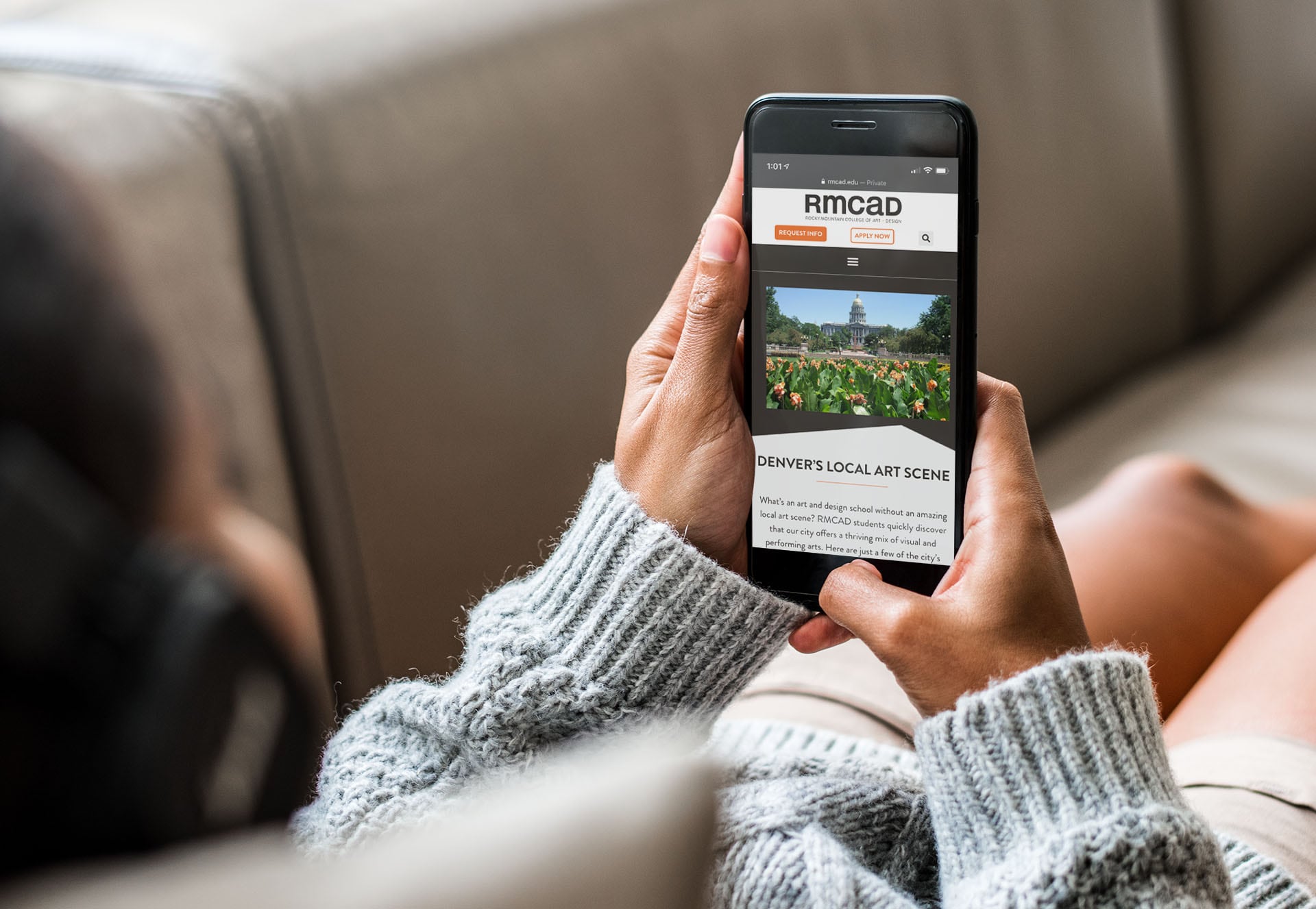 RMCAD website displayed on a mobile device in the user's home, as they scroll through the Exploring Denver page.